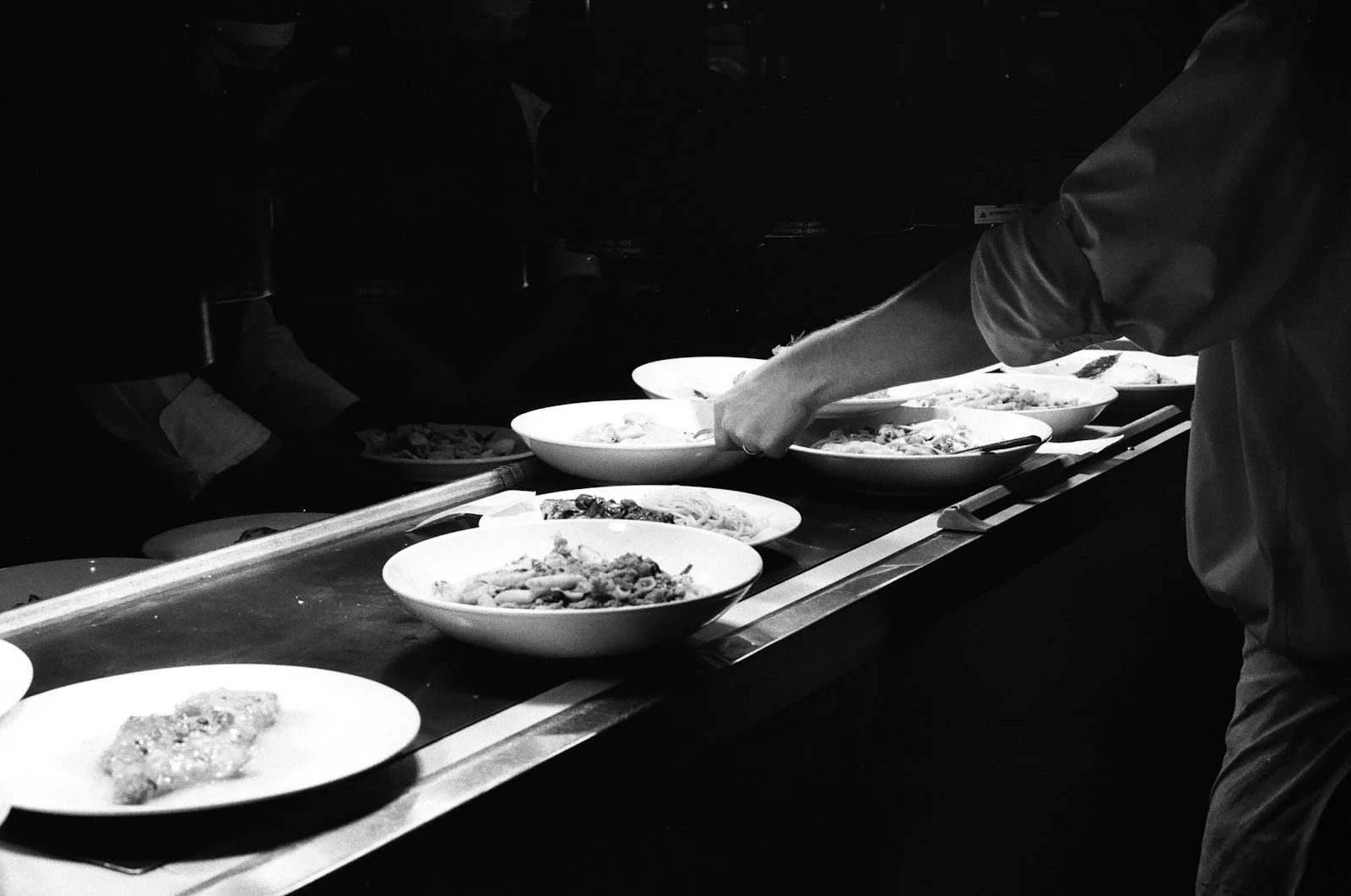 Pase de cocina en blanco y negro con platos listos para salir