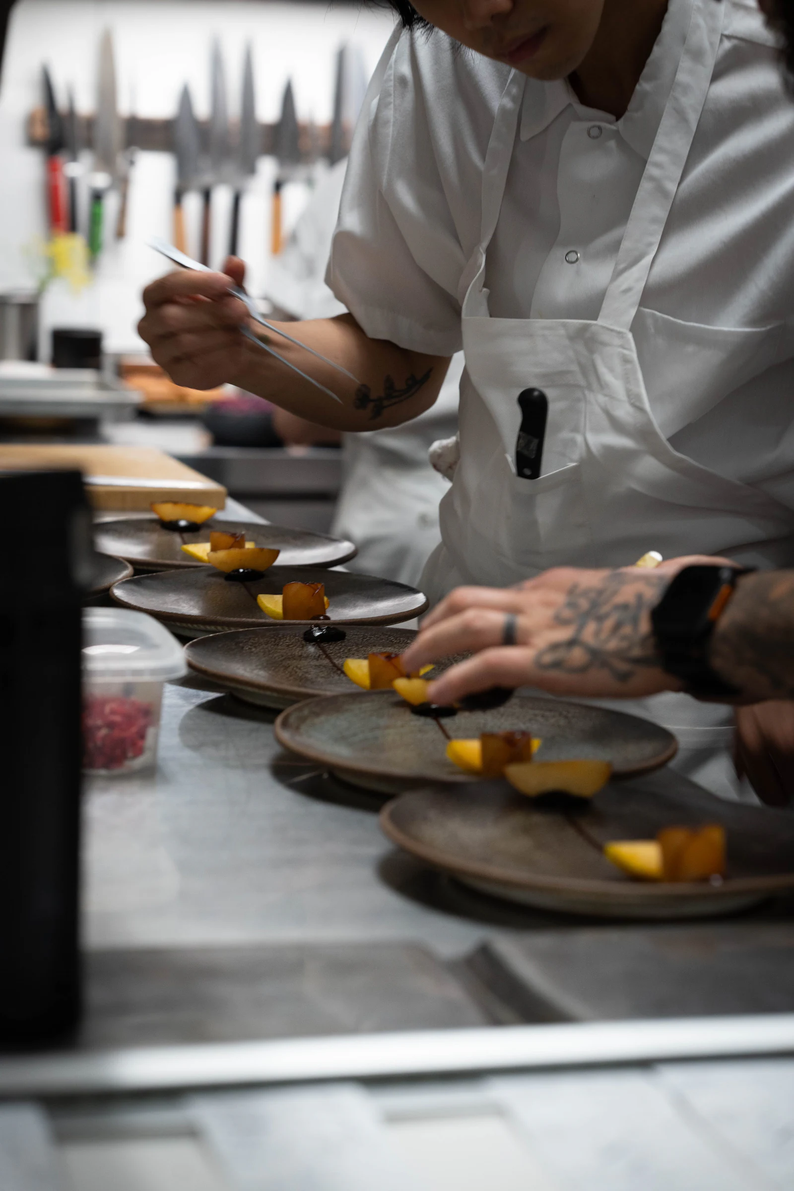 Varios platos emplatándose a la vez en el pase de cocina